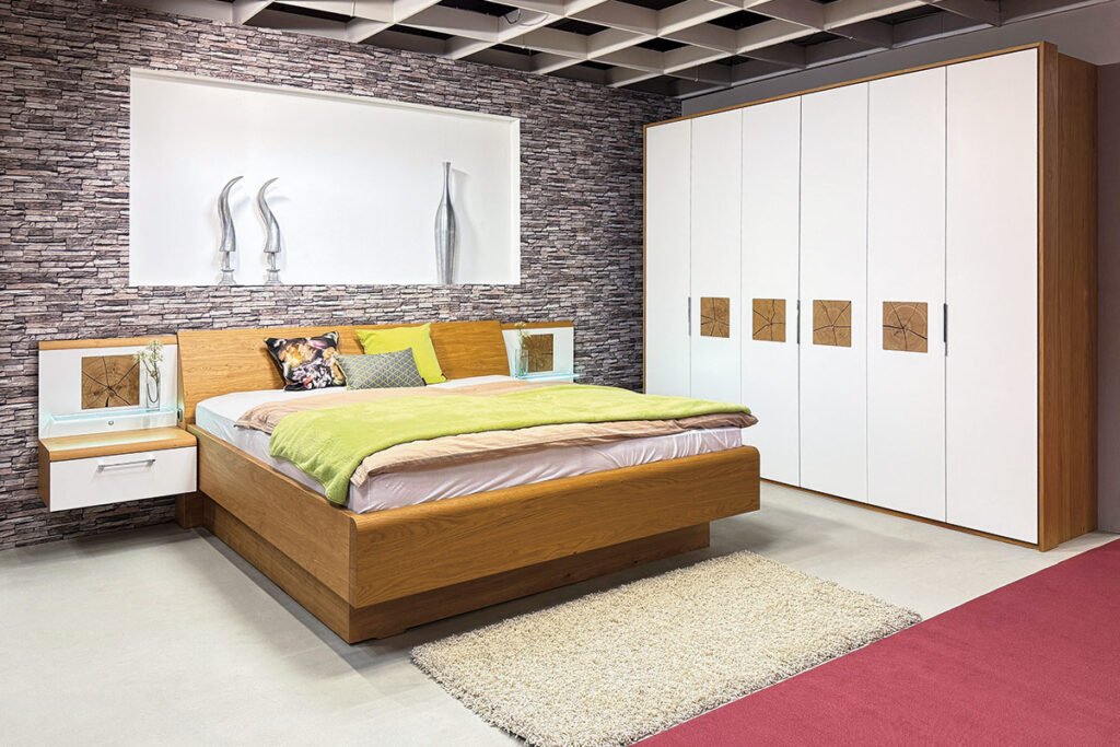 Schlafzimmer Wildeiche, Lack Weiß, bestehend aus 6-türigem Drehtüren-Kleiderschrank mit vier Applikation Hirnholzscheiben und Bettanlage, inkl. Nachtkonsolen mit einer Schublade und einer Glasablage, rechts und links jeweils eine Applikation Hirnholzscheibe