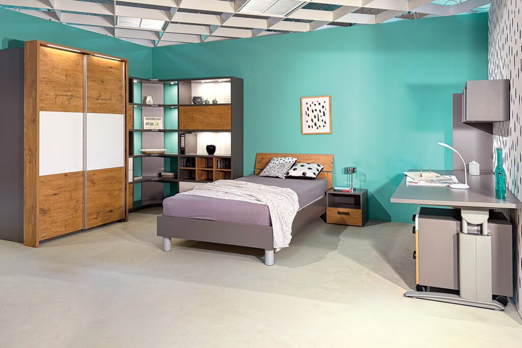 Jugendzimmer Grau/Weiß/Wildeiche, best. aus Schwebetürenkleiderschrank mit Beleuchtung, Eckregal mit zahlreichen Fächern, überwiegend offen aber ein paar sind auch geschlossen, Bett, Nachtkonsole mit einer Schublade unten und einem offenen Fach oben, Regal, Schreibtisch, Rollcontainer mit 3 Schubladen und 2 Wandregalen