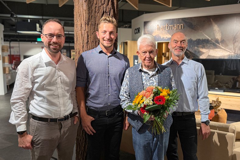 3 Personen die einen Blumenstrauß an Herrn Niggemann übergeben
