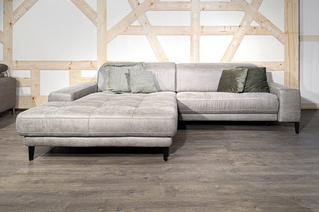 Eckkombination Mikrofaser Taupe mit schwarzen Füßen und zwei Kissen hellgrün und zwei Kissen dunkelgrün