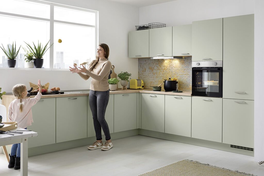 Front Lack Jade Premium matt, Arbeitsplatte Eiche San Remo Nachbildung, Nischenverkleidung Golden Luxury, bestehend aus L-Küche mit Hochschränken und Hängern. Mit hochwertigen Elektrogeräten von Constructa und Einbauspüle, ohne Deko