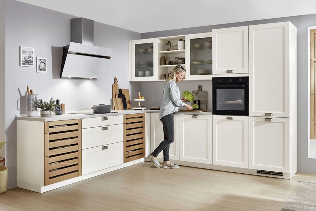 Front Lacklaminat Weiß, Korpus Weiß, Arbeitsplatte Terrazzo Weiß Nachbildung mit Glashängern, Regal und zwei Auszugschränken mit Frontblenden in Eichen Massivholz, mit Elektrogeräten und Einbauspüle, ohne Deko