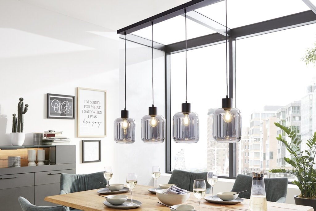 Pendelleuchte mit vier rauchgrauen Glaskugeln und schwarzen Fassungen