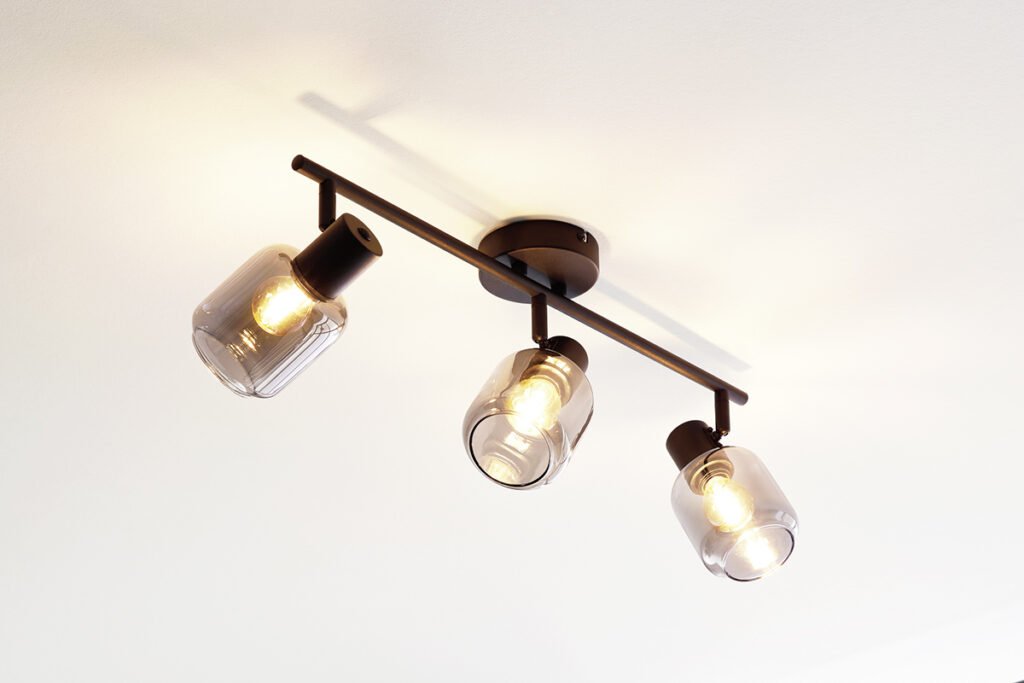 Deckenleuchte mit drei rauchgrauen Glaskugeln und schwarzen Fassungen