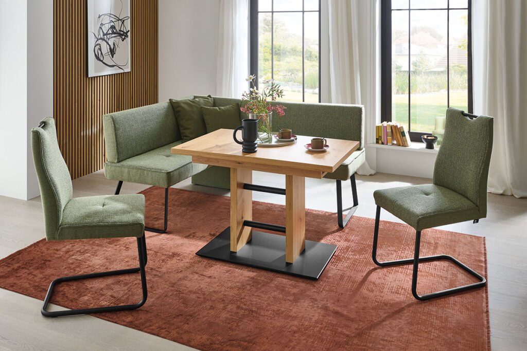 Speisegruppe, bestehend aus Esstisch Asteiche Nachbildung, Rohre und Bodenplatte Metall Schwarz Struktur, Eckbank Stoff Oliv und Schwingstühlen.