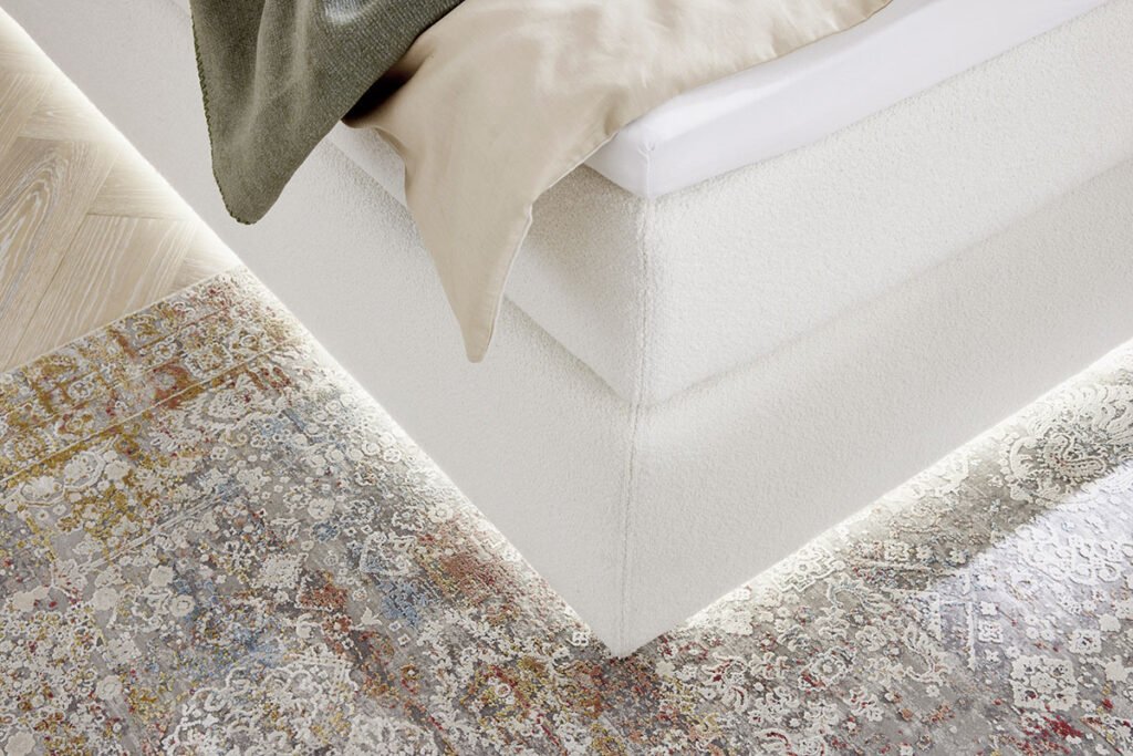 Boxspringbett, Stoff Weiß, mit dezenter Beleuchtung unter dem Bett, Nahaufnahme